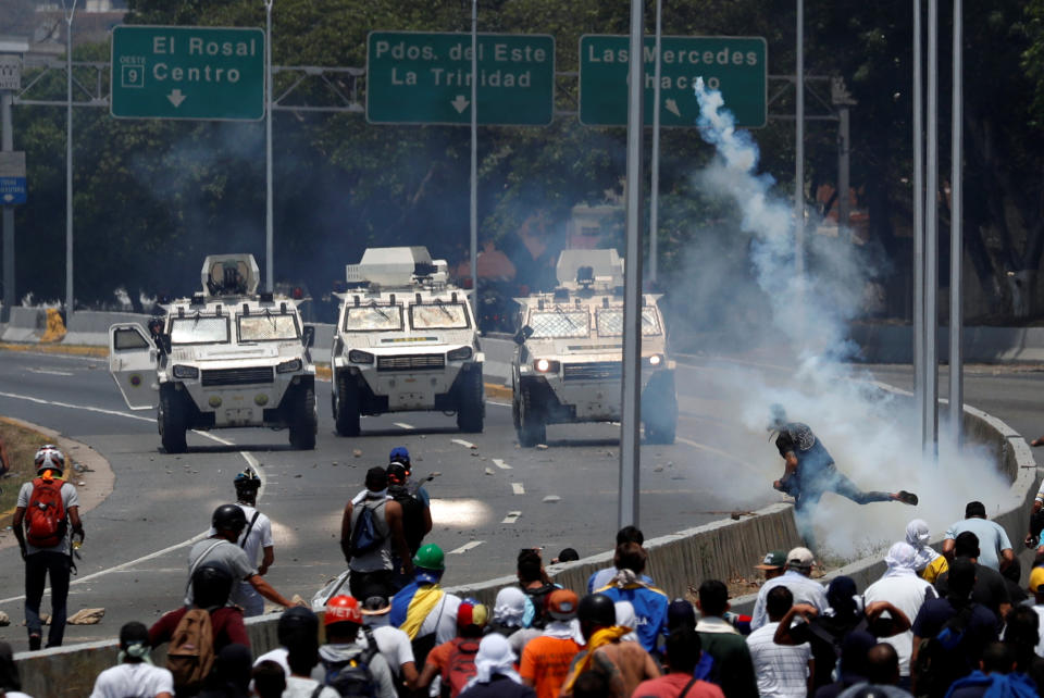 Opposition demonstrators face military vehicles near the Generalisimo Francisco de Miranda Airbase “La Carlota” in Caracas