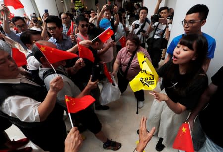 Pro-government and anti-government supporters chant against one another at a shopping mall in Hong Kong