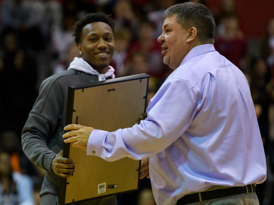 Former Bosse player Mekhi Lairy smiles as Bosse Coach Shane Burkhart hands him a framed jersey during a jersey retirement ceremony at the season opening game against the Terre Haute South Braves in Evansville, Friday evening, Dec. 6, 2019. Lairy broke the city’s all-time scoring record in 2018 and currently plays for the Miami (Ohio) Redhawks.