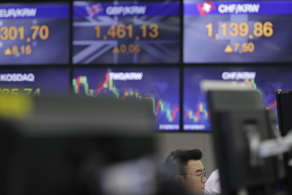 A currency trader watches the computer monitors near the screens the foreign exchange rates at the foreign exchange dealing room in Seoul, South Korea, Tuesday, Oct. 23, 2018. Asian stocks slid on Tuesday as worries about softening Chinese growth rattled investors, following a rally that was not picked up by Wall Street overnight. (AP Photo/Lee Jin-man)