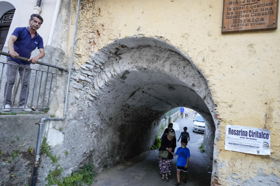 Rabbi Barbara Aiello, bottom center, holds hand with Noah Blum, 10, as she guides him with his family for a tour of the Jewish quarter of Lamezia Terme, southern Italy, Thursday, July 7, 2022. From a rustic, tiny synagogue she fashioned from her family's ancestral home in this mountain village, American rabbi Aiello is keeping a promise made to her Italian-born father: to reconnect people in this southern region of Calabria to their Jewish roots, links nearly severed five centuries ago when the Inquisition forced Jews to convert to Christianity. (AP Photo/Andrew Medichini)