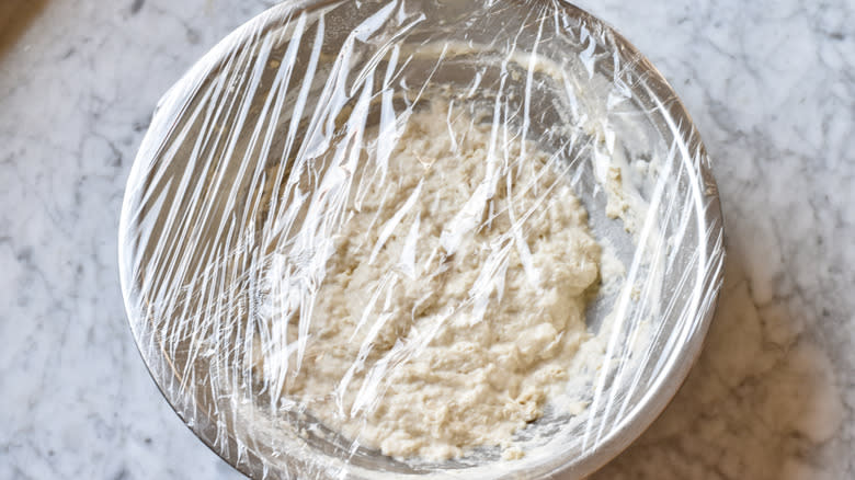 covering bread dough with plastic