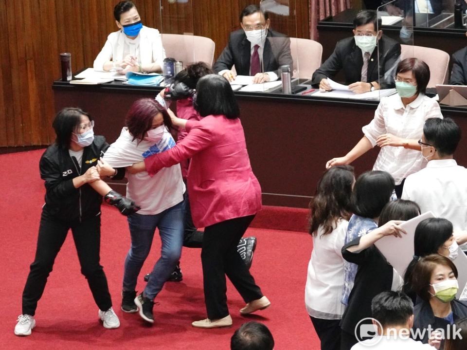 國民黨陳玉珍要衝往主席台方向，遭民進黨立委擋下來。   圖：張良一/攝