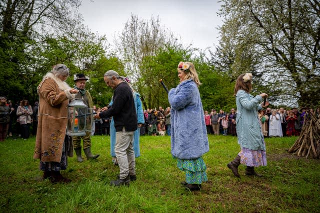 A candle flame is used to light the Beltane bonfire