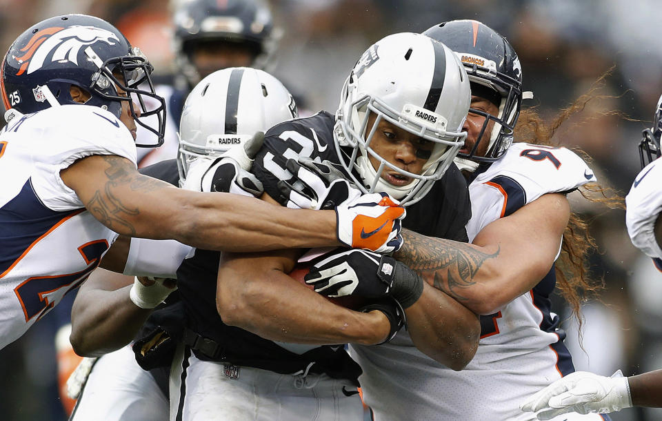 <p>Oakland Raiders running back DeAndre Washington (33) is tackled by Denver Broncos defenders during the first half of an NFL football game in Oakland, Calif., Sunday, Nov. 26, 2017. (AP Photo/D. Ross Cameron) </p>
