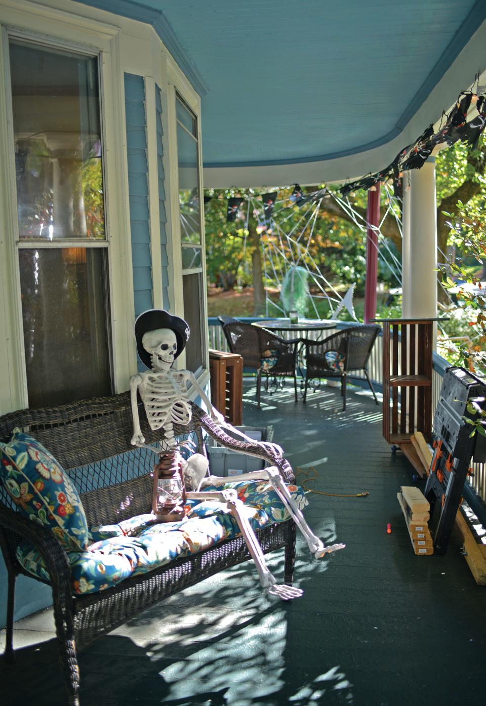 A skeleton relaxes on the wraparound porch.