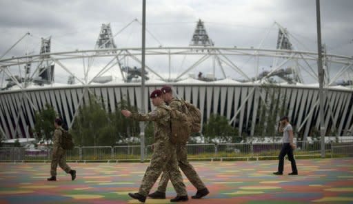 British military personnel walk past the Olympic Stadium ahead of the London 2012 Olympic Games in the Olympic Park in east London