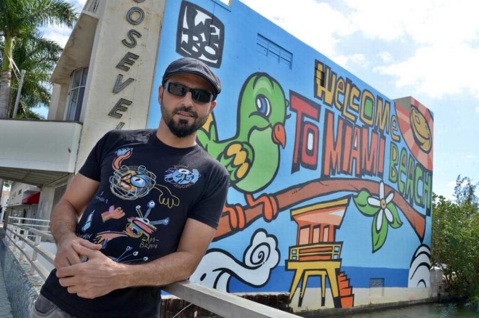 Cuban American artist Lebo poses in front of his mural “Welcome to Miami Beach” painted on the walls of the abandoned Roosevelt Theater. The artist died on Aug. 1, 2023 after battling an illness.