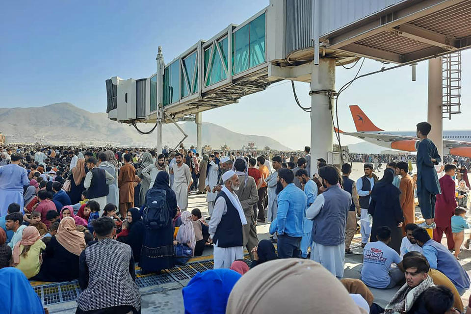 Afghans crowd at the tarmac of the Kabul airport on August 16, 2021, to flee the country as the Taliban were in control of Afghanistan after President Ashraf Ghani fled the country and conceded the insurgents had won the 20-year war. (Photo by - / AFP) (Photo by -/AFP via Getty Images)