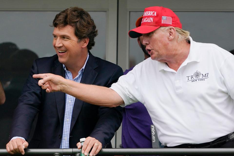 Tucker Carlson, left, and former President Donald Trump, talk while watching golfers on the 16th tee during the final round of the LIV Golf Invitational at Trump National in Bedminster, N.J., July 31, 2022. A defamation lawsuit against Fox News is revealing blunt behind-the-scenes opinions by its top figures about Donald Trump, including a Tucker Carlson text message where he said “I hate him passionately.” Carlson's private conversation was revealed in court papers at virtually the same time as the former president was hailing the Fox News host on social media for a “great job” for using U.S. Capitol security video to produce a false narrative of the Jan. 6, 2021, insurrection.  (AP Photo/Seth Wenig, File) ORG XMIT: WX101