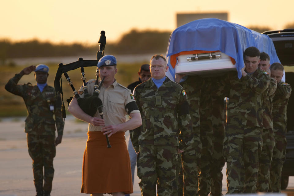 Irish U.N. peacekeepers, carry the coffin draped by their country flag of their comrade Pvt. Seán Rooney who was killed during a confrontation with residents near the southern town of Al-Aqbiya on Wednesday night, during his memorial procession at the Lebanese army airbase, at Beirut airport, Sunday, Dec. 18, 2022. (AP Photo/Hussein Malla)