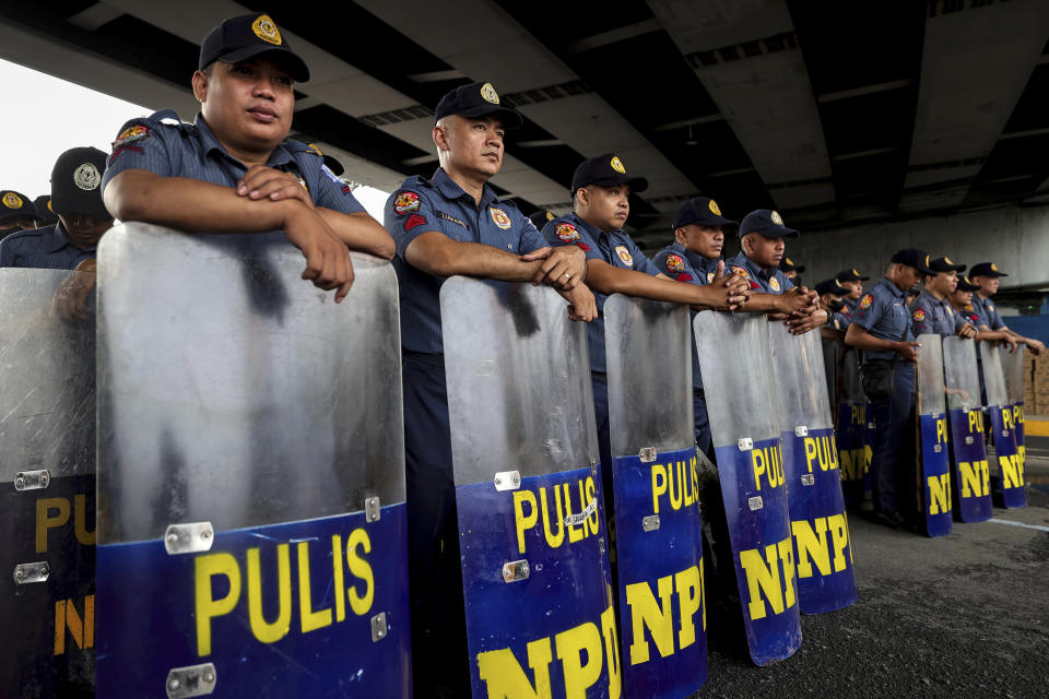 CORRECTS SPELLING OF THE PRESIDENT'S LAST NAME TO MARCOS - Police personnel stand in formation with shields along the main thoroughfare leading to the House of Representatives in Quezon City, Philippines, on Monday, July 24, 2023, ahead of the second State of the Nation Address of Philippine President Ferdinand Marcos Jr. (AP Photo/Gerard Carreon)