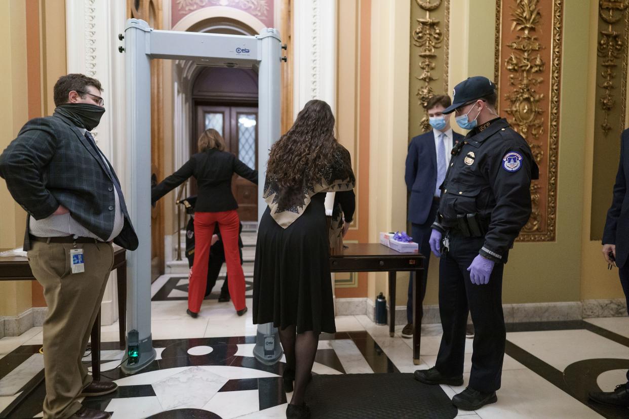 Congressional staffers pass through a metal detector and security screening as they enter the House chamber, measures put into place after the Jan. 6 riot at the U.S. Capitol. (Photo: J. Scott Applewhite/Associated Press)
