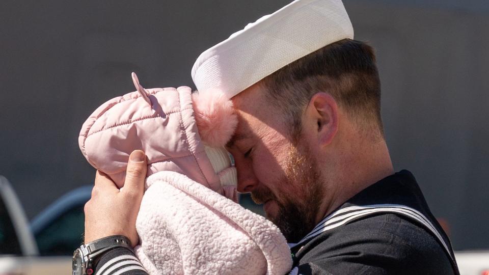 Machinist's Mate 2nd Class Adam Huggins, assigned to the amphibious assault ship Bataan, greets his family after Bataan returned to Naval Station Norfolk, Virginia, on Thursday following an eight and a half-month deployment (Mass Communication Specialist 2nd Class Anderson W. Branch/Navy)