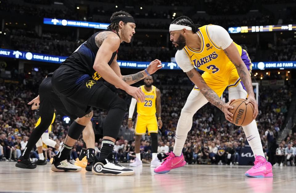 Anthony Davis controls the ball in front of Aaron Gordon.