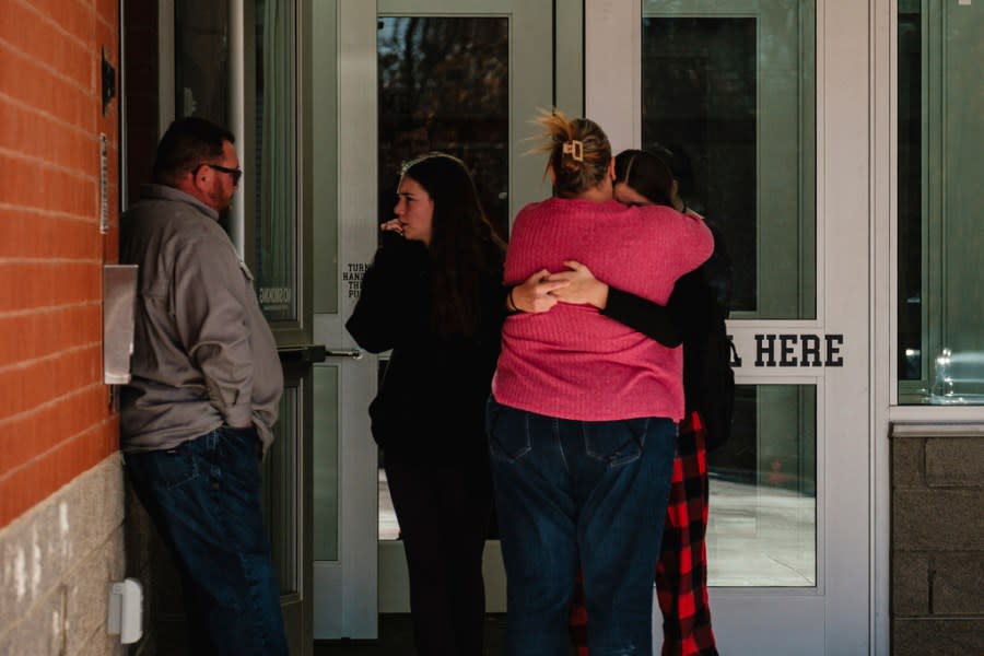 Parents and students embrace, Tuesday, Nov. 14, 2023, outside Tuscarawas Valley Middle/High School in Zoarville, Ohio, as children are gradually let out of school early. A charter bus filled with high school students was rear-ended by a semitruck on an Ohio highway earlier in the day, leaving several people dead and multiple others injured. (Andrew Dolph/Times Reporter via AP)