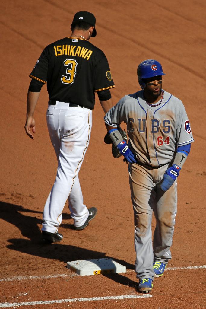 Chicago Cubs' Emilio Bonifacio (64) walks off first base after being ruled out by home plate umpire John Hirschbeck, as the result of review requested by Pittsburgh Pirates manager Clint Hurdle of a pickoff safe call at first base by umpire Bob Davidson in the tenth inning the opening day baseball game against the Chicago Cubs on Monday, March 31, 2014, in Pittsburgh. The Pirates won 1-0 in ten innings. (AP Photo/Gene J. Puskar)