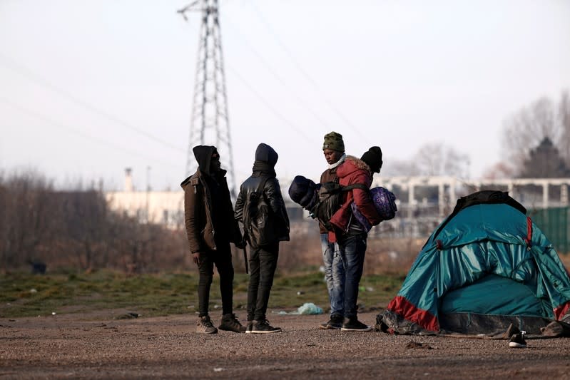 FILE PHOTO: Migrants carry their belongings after the dismantling their makeshift camp near Calais Port