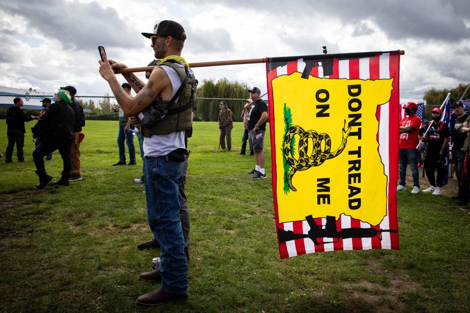 A man holds a Gadsden flag as several hundred members of the Proud Boys and other similar groups gathered for a rally at Delta Park in Portland, Oregon on September 26, 2020.