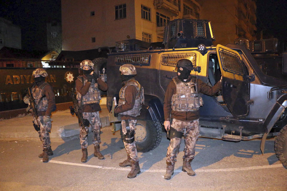 Turkish anti-terrorism police stand by their armoured vehicle during an operation to arrest people over alleged links to the Islamic State group, in Adiyaman, southeastern Turkey, early Sunday, Feb. 5, 2017. Turkey's state-run agency says anti-terrorism police has detained more than 400 people in simultaneous police operations that spanned several cities, including Istanbul and Gaziantep near the border with Syria, according to the report. (Mahir Alan/Dha-Depo Photos via AP)