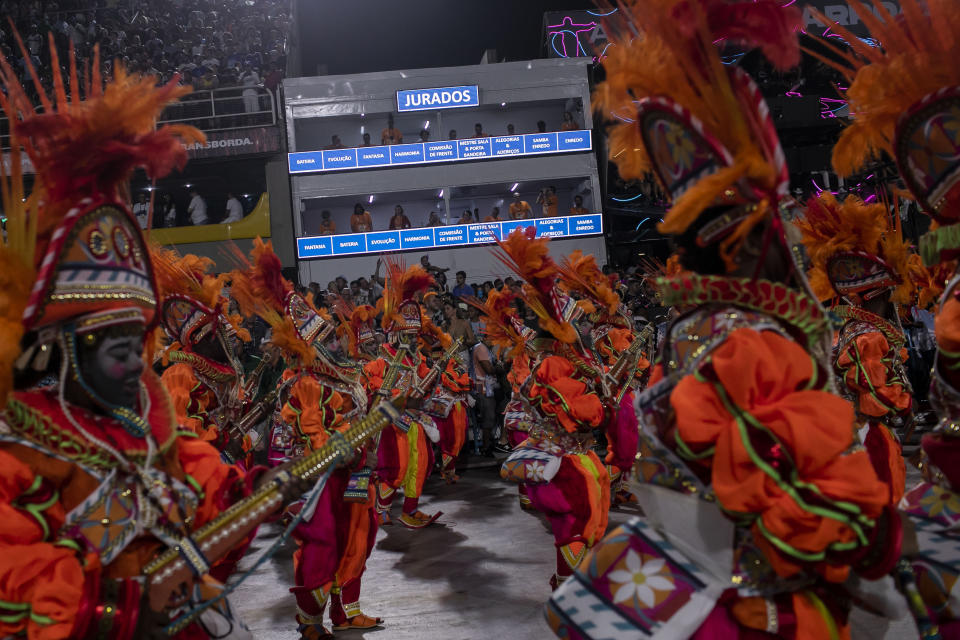 Judges from the Independent League of Samba Schools in Rio de Janeiro, watch and evaluate samba schools parading for Carnival through the Sambadrome in Rio de Janeiro, Brazil, Tuesday, Feb. 21, 2023. (AP Photo/Bruna Prado)