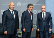 FILE - In this Wednesday, March 22, 2017 file photo, from right, Russian President Vladimir Putin, former French Prime Minister Francois Fillon and businessman Fouad Makhzoumi pose for photographers during their meeting on the sidelines of an economic forum in St. Petersburg, Russia. The Kremlin is dismissing a report that French presidential candidate Francois Fillon made 50,000 euros to set up a meeting between Russian President Vladimir Putin and a Lebanese oil magnate Fouad Makhzoumi at an economic forum in 2015. (Mikhail Klimentyev, Sputnik, Kremlin Pool Photo via AP)