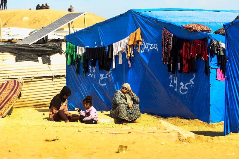 Displaced Palestinians sit in front of a makeshift tent as they struggle to find clean water, food and medicine as Israeli attacks continue in Rafah in the southern Gaza Strip on February 10, 2024. Photo by Ismael Mohamad/UPI