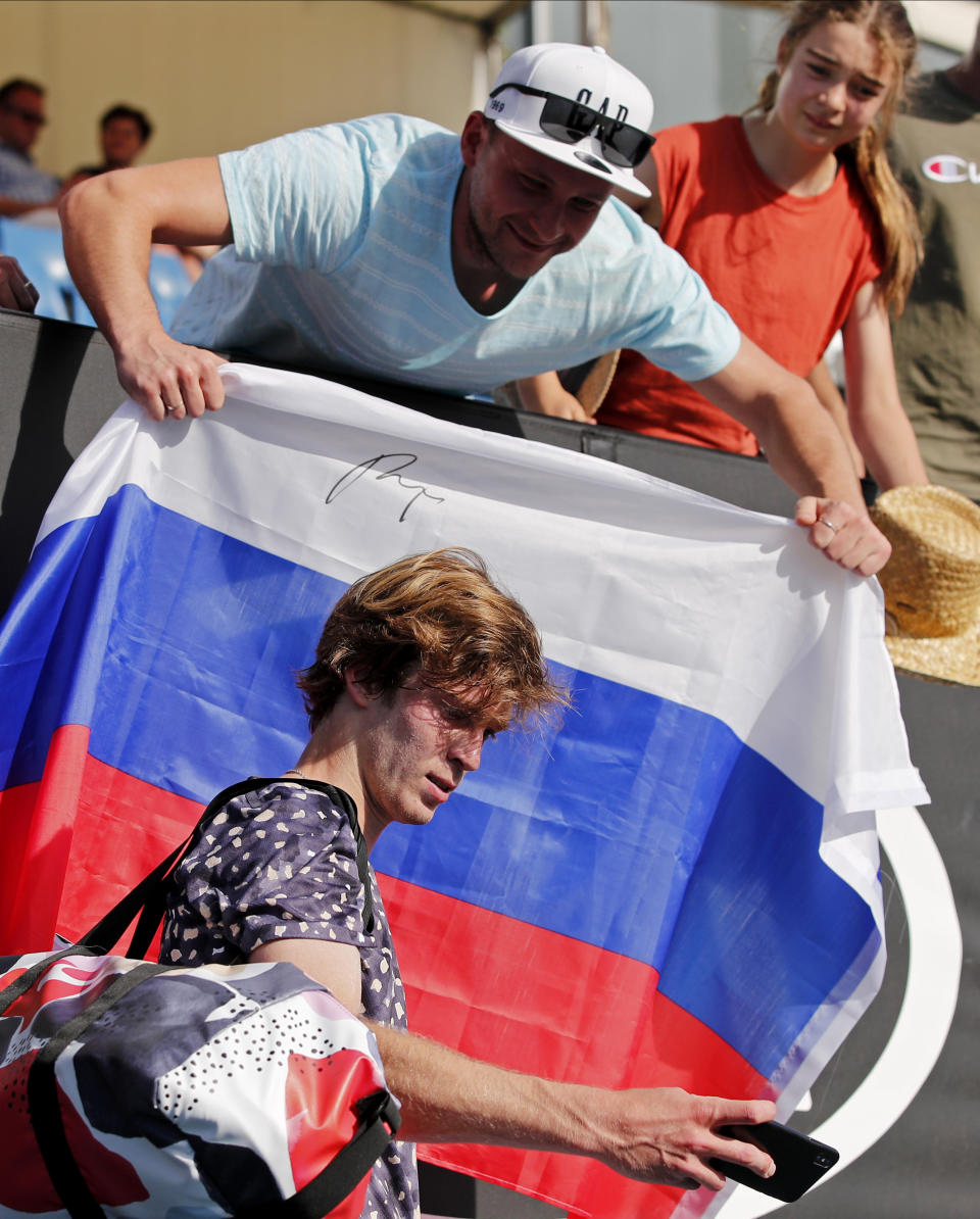 Russia's Andrey Rublev takes a selfie with supporters after defeating Belgium's David Goffin in their third round match at the Australian Open tennis championship in Melbourne, Australia, Saturday, Jan. 25, 2020. (AP Photo/Andy Wong)