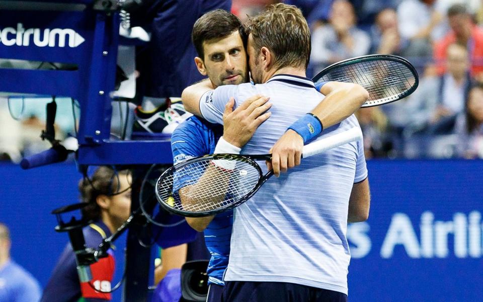 Novak Djokovic and Stan Wawrinka (R) embrace at the end of their fourth-round match - REX