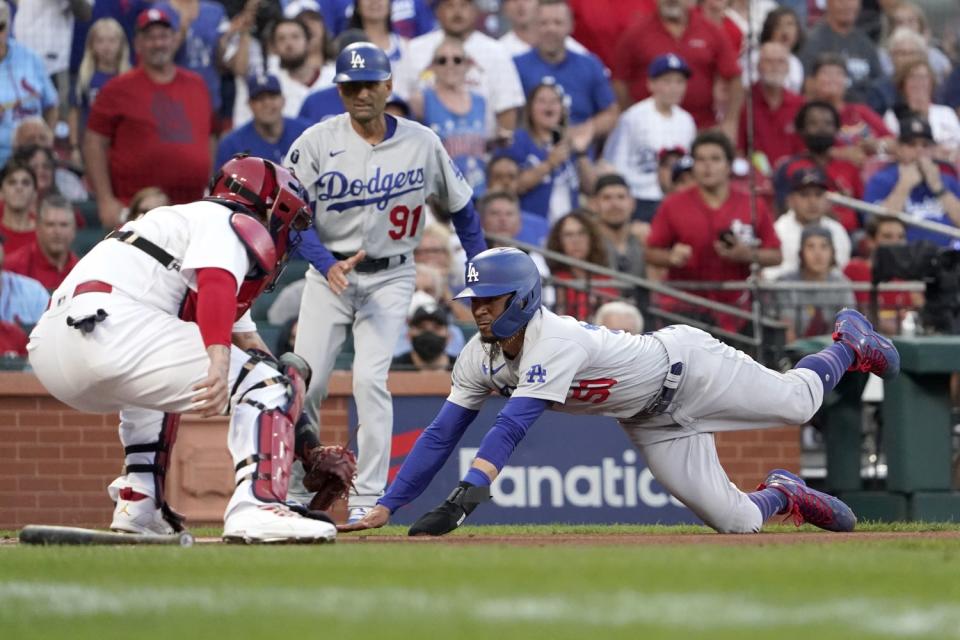 St. Louis Cardinals catcher Yadier Molina prepares to tag Dodgers' Mookie Betts out at home.