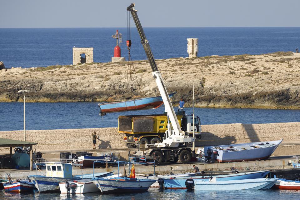 Boats used by migrants to cross the Mediterranean sea are removed from the harbor of the Sicilian Island of Lampedusa, Italy, Thursday, Aug. 4, 2022. Italy's former firebrand interior minister, Matteo Salvini, is campaigning to get his old job back. Salvini is making a stop Thursday on Italy's southernmost island of Lampedusa, the gateway to tens of thousands of migrants arriving in Italy each year across the perilous central Mediterranean Sea. (AP Photo/David Lohmueller)