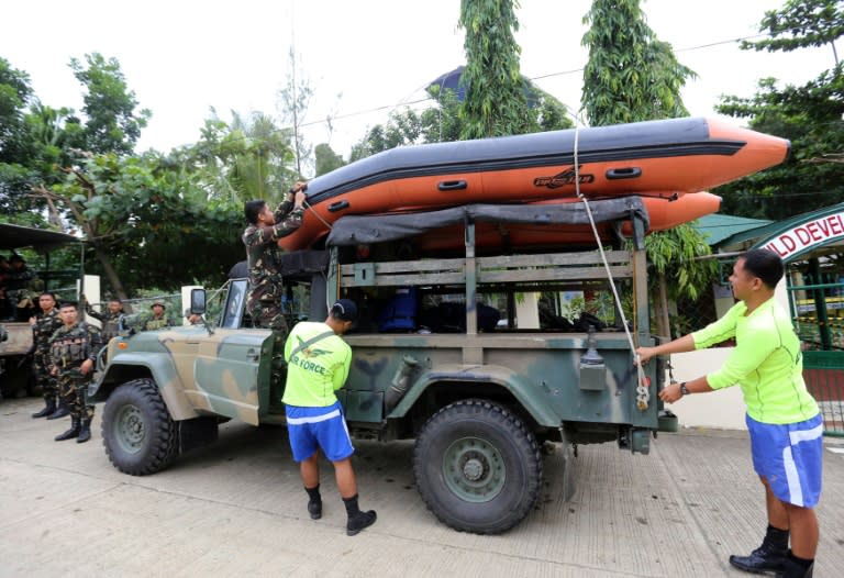 Rescuers load a rubber boat onto their vehicle as they prepare for the arrival of Typhoon Haima in Ilagan town, Isabela Province, on October 19, 2016