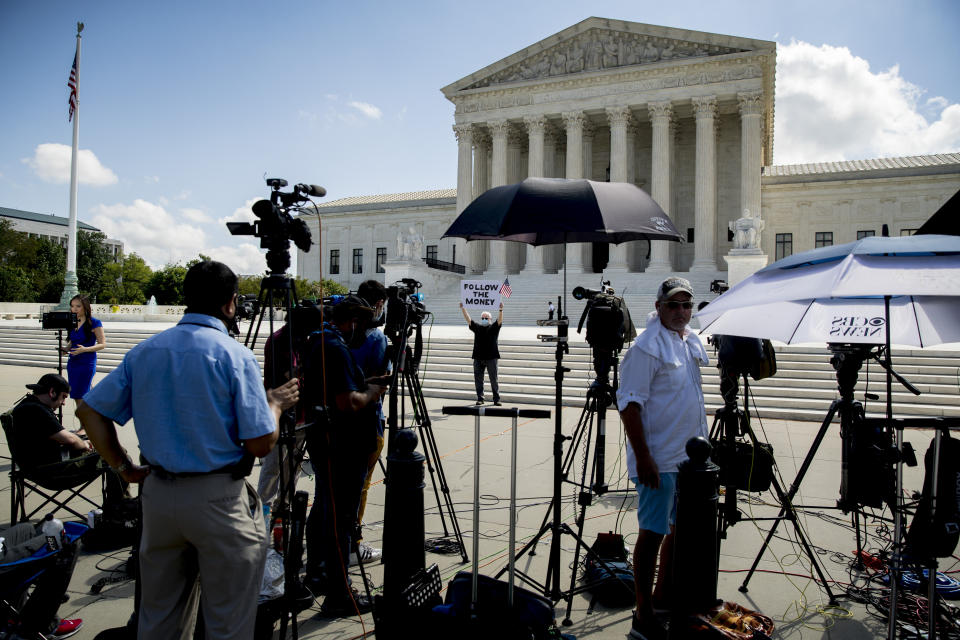 Bill Christeson holds up a sign that reads "Follow the Money" outside the Supreme Court, Thursday, July 9, 2020, in Washington. The Supreme Court ruled Thursday that the Manhattan district attorney can obtain Trump tax returns while not allowing Congress to get Trump tax and financial records, for now, returning the case to lower courts. (AP Photo/Andrew Harnik)