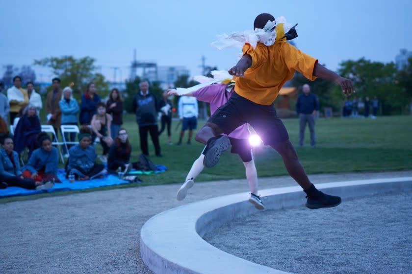 Members of Heidi Duckler Dance perform for spectators seated and standing on the lawn at Los Angeles State Historic Park.