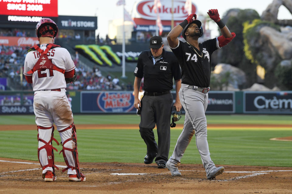 Chicago White Sox's Eloy Jimenez, right, gestures as he scores after hitting a solo home run while Los Angeles Angels catcher Matt Thaiss, left, and home plate umpire Chad Whitson stand by during the third inning of a baseball game Wednesday, June 28, 2023, in Anaheim, Calif. (AP Photo/Mark J. Terrill)