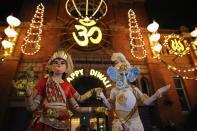 LEICESTER, UNITED KINGDOM - NOVEMBER 13: People dressed as the gods, Lord Ganesha and Goddess Lakshmi, walk through the streets during the Hindu festival of Diwali on November 13, 2012 in Leicester, United Kingdom. Up to 35,000 people attended the Diwali festival of light in Leicester's Golden Mile in the heart of the city's asian community. The festival is an opportunity for Hindus to honour Lakshmi, the goddess of wealth and is one of the biggest in the world outside India. Sikhs and Jains also celebrate Diwali. (Photo by Christopher Furlong/Getty Images)