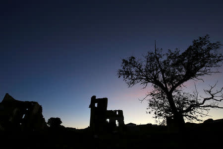 The sun sets over ruins in the old village of Belchite, in northern Spain, November 13, 2016. REUTERS/Andrea Comas