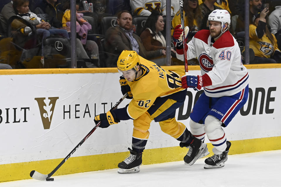 Nashville Predators center Thomas Novak (82) moves the puck ahead of Montreal Canadiens right wing Joel Armia (40) during the second period of an NHL hockey game Saturday, Dec. 4, 2021, in Nashville, Tenn. (AP Photo/Mark Zaleski)