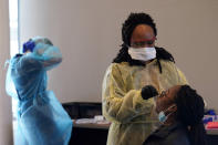 Jazmyn Finney, seated, is administered a coronavirus rapid test by a certified medical assistant at the student health center on campus at North Carolina Agricultural and Technical State University in Greensboro, N.C., Wednesday, Feb. 3, 2021. As vaccinations slowly ramp up, some experts say turning to millions more rapid tests that are cheaper but technically less accurate may improve the chances of identifying sick people during the critical early days of infection, when they are most contagious. (AP Photo/Gerry Broome)