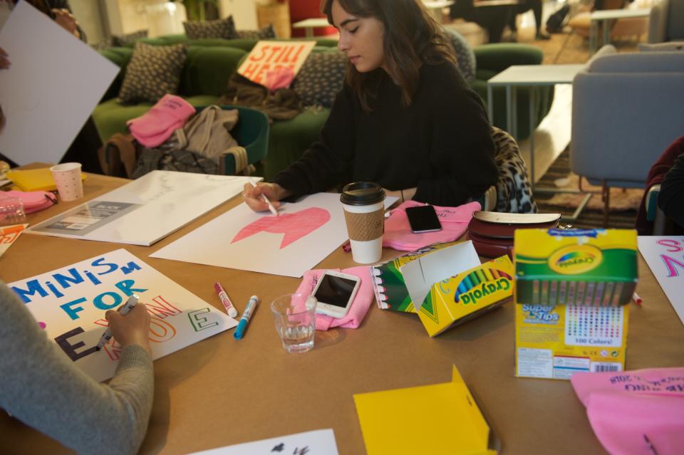 Marchers make signs at women's co-working space and social club, The Wing.