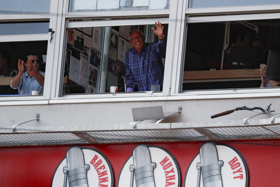 Cincinnati Reds announcer Marty Brennaman, center, waves to the crowd after the close of the fourth inning of a baseball game against the Milwaukee Brewers, Thursday, Sept. 26, 2019, in Cincinnati. (AP Photo/John Minchillo)