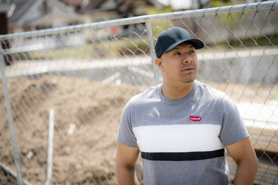 Fidel Martinez stands for a portrait at one of his former worksites in Minneapolis on Sunday, April 18, 2021. Martinez worked for a demolition contractor in the fall of 2020, demolishing several Walgreens stores and other structures. Martinez said the contractor owed him and his co-workers more than $20,000. His boss kept telling him the money was coming, but he would get his paychecks weeks late, and many of them he didn't get at all. (AP Photo/John Minchillo)