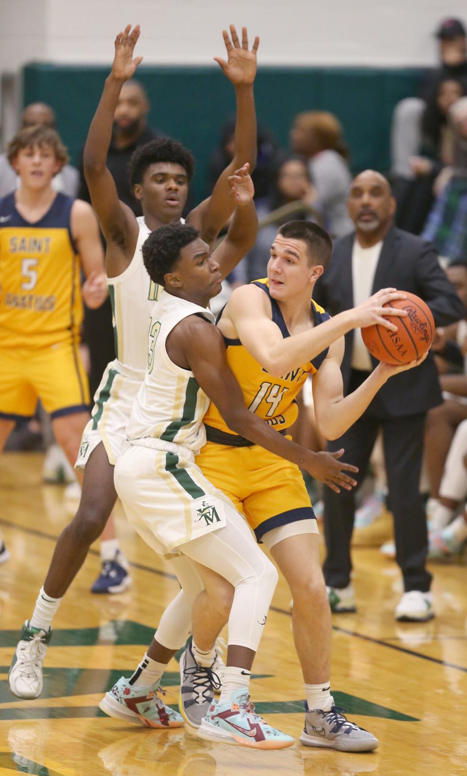 St. Vincent-St. Mary's Lance Hayes, top, and Torell Hopson II trap Cleveland St. Ignatius' Bradyn Sczepaniak on Thursday night at LeBron James Arena. The Irish won the game 56-38. [Phil Masturzo/Beacon Journal]