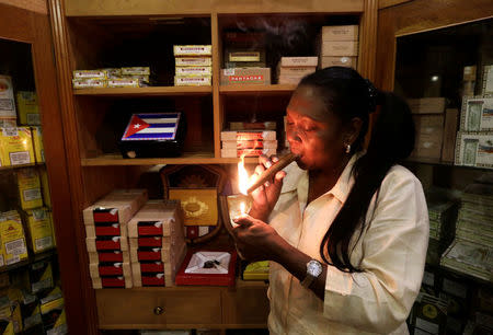 Staff member Juanita, 62, smokes a hand-rolled cigar at a hotel in Havana, Cuba October 14, 2016. REUTERS/Enrique de la Osa