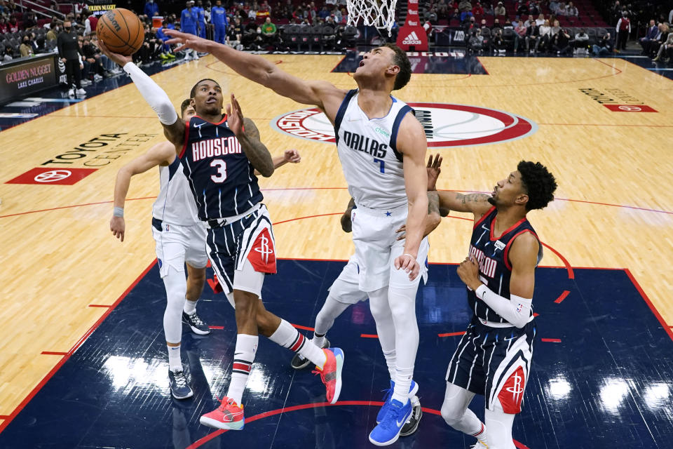 Houston Rockets guard Kevin Porter Jr. (3) shoots as Dallas Mavericks center Dwight Powell, center, defends during the first half of an NBA basketball game Friday, Jan. 7, 2022, in Houston. (AP Photo/Eric Christian Smith)