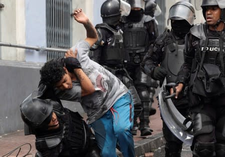 Riot police detain a man during protests after Ecuador's President Lenin Moreno's government ended four-decade-old fuel subsidies, in Quito