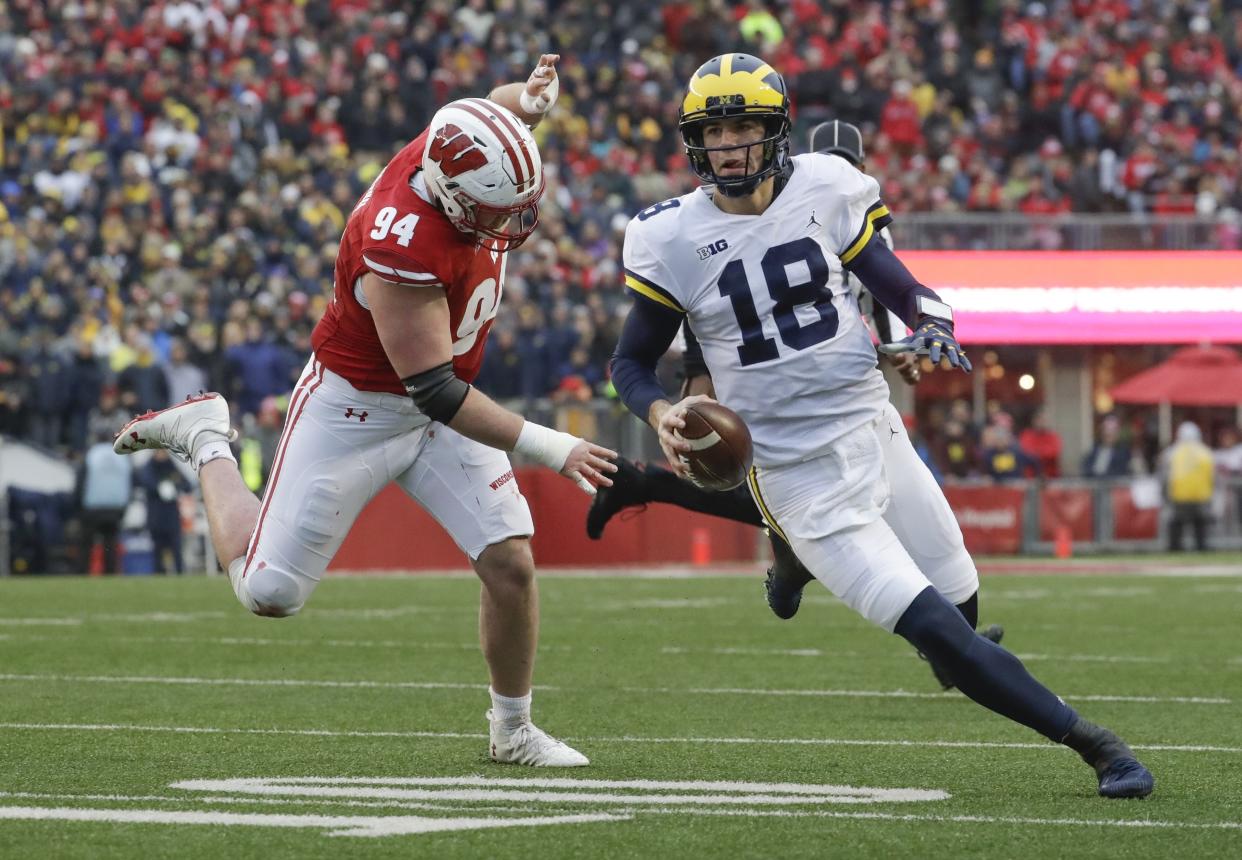 Michigan quarterback Brandon Peters runs past Wisconsin’s Chris Orr during the first half of an NCAA college football game Saturday, Nov. 18, 2017, in Madison, Wis. (AP Photo/Morry Gash)