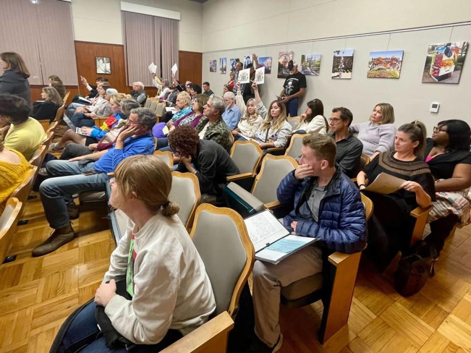 Attendees hold up signs at the San Luis Obispo City Council on Nov. 7, 2023, as speakers share how parking challenges were impacting the downtown. Kaytlyn Leslie/kleslie@thetribunenews.com