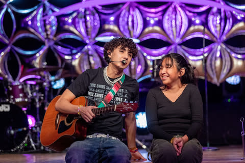 Ashley, paciente de St. Jude, se une al artista musical DannyLux en el escenario durante una presentación en vivo en 2023 (Foto: Business Wire)