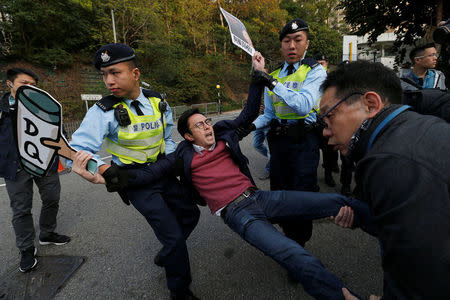 A pro-democracy protester against the disqualification of lawmakers is taken away by the police before Hong Kong Chief Executive Carrie Lam arrives to vote during a Legislative Council by-election in Hong Kong, China March 11, 2018. REUTERS/Bobby Yip